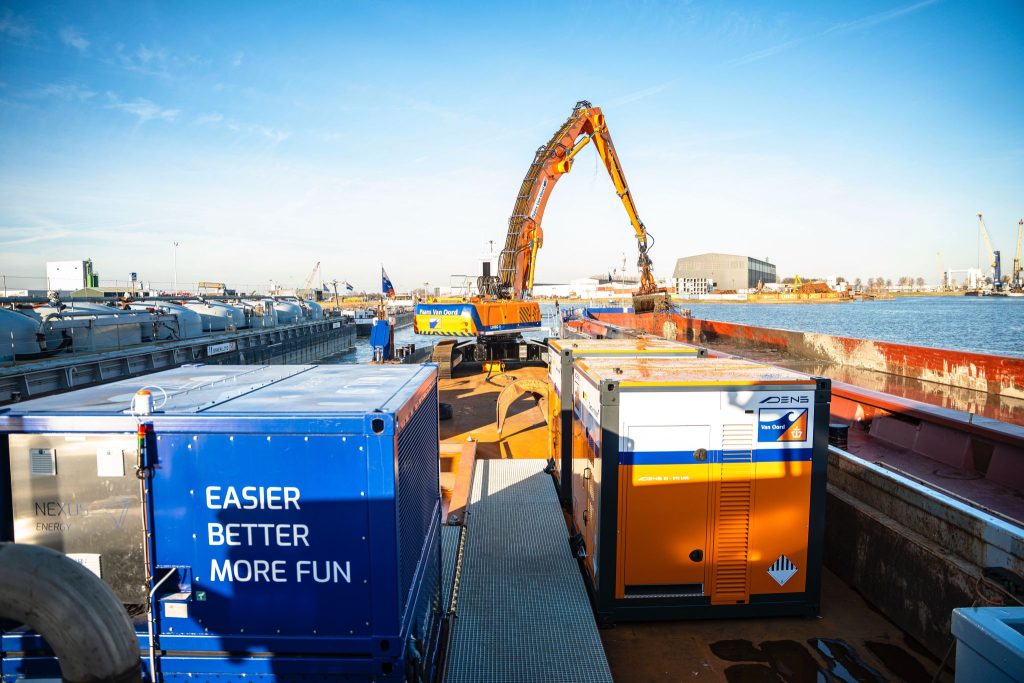 Kraan werkt vanaf de boot met accu container